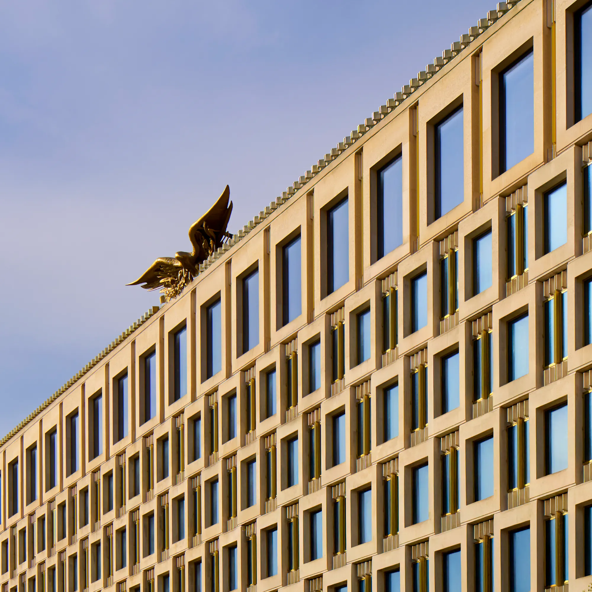 An exterior view of The Chancery Rosewood hotel in London, featuring the iconic golden eagle sculpture on the roof.