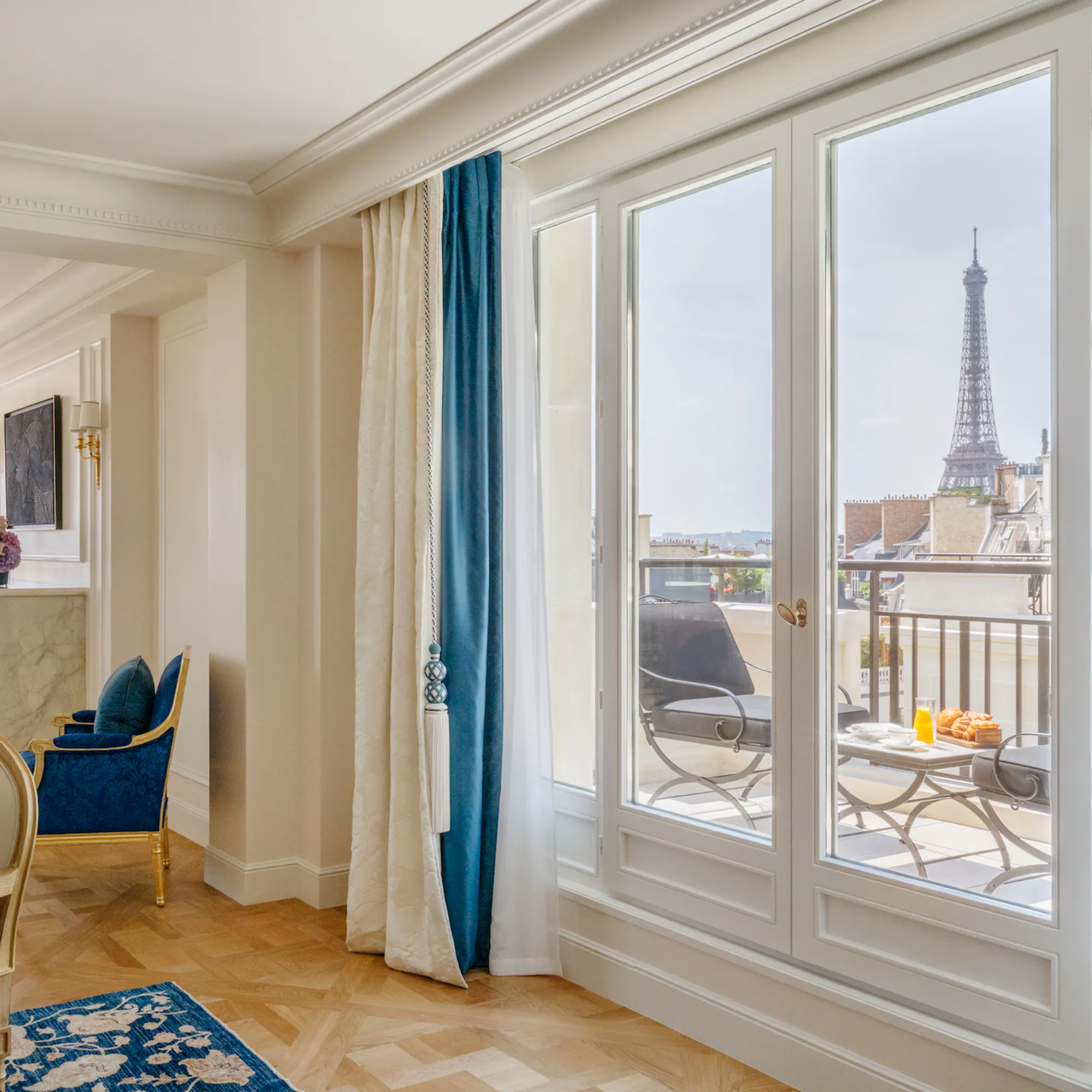 A suite at Four Seasons Hotel George V, Paris, with views over the Eiffel Tower and city rooftops.
