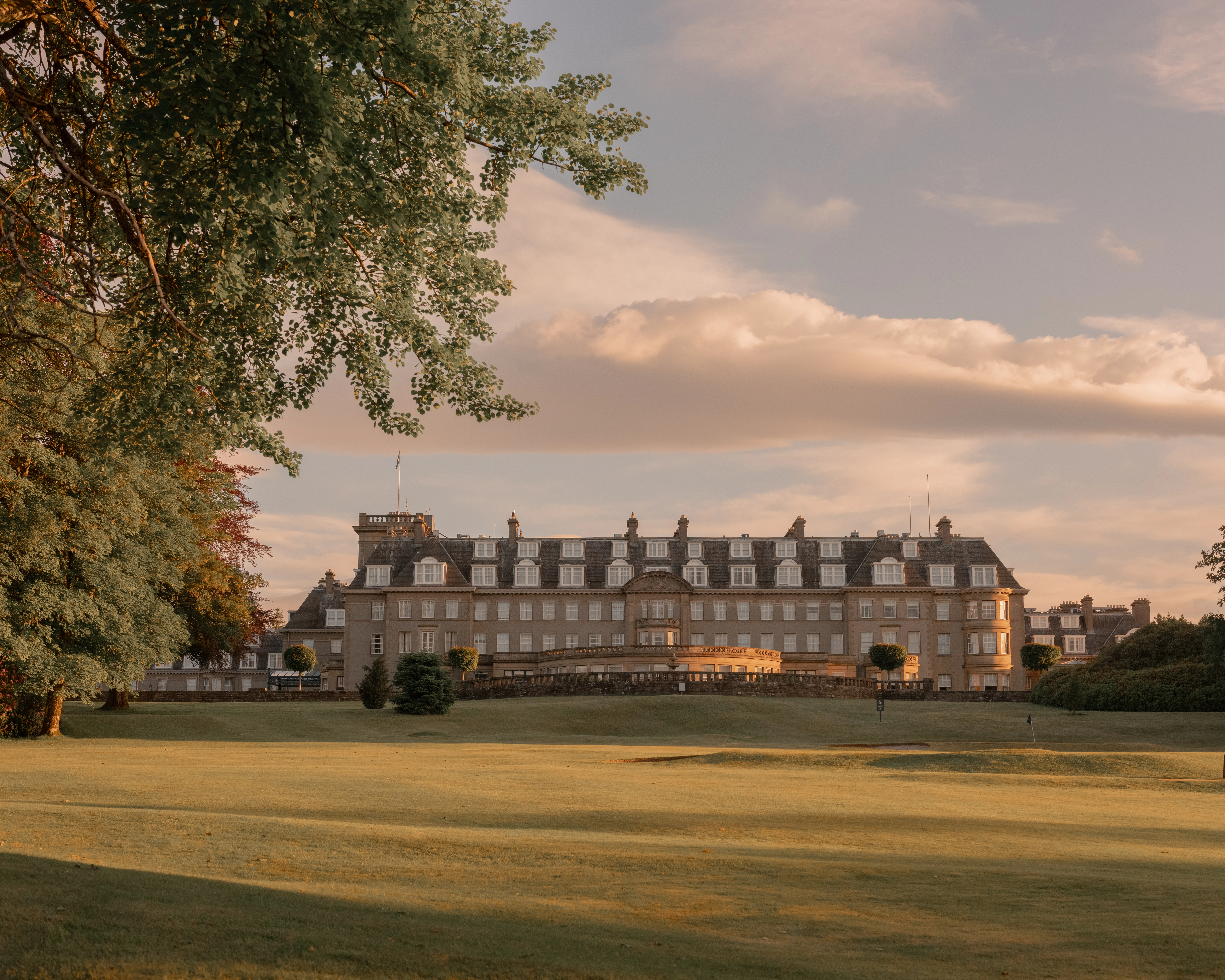 Gleneagles Hotel at sunset, its sandstone facade overlooking the golf course.
