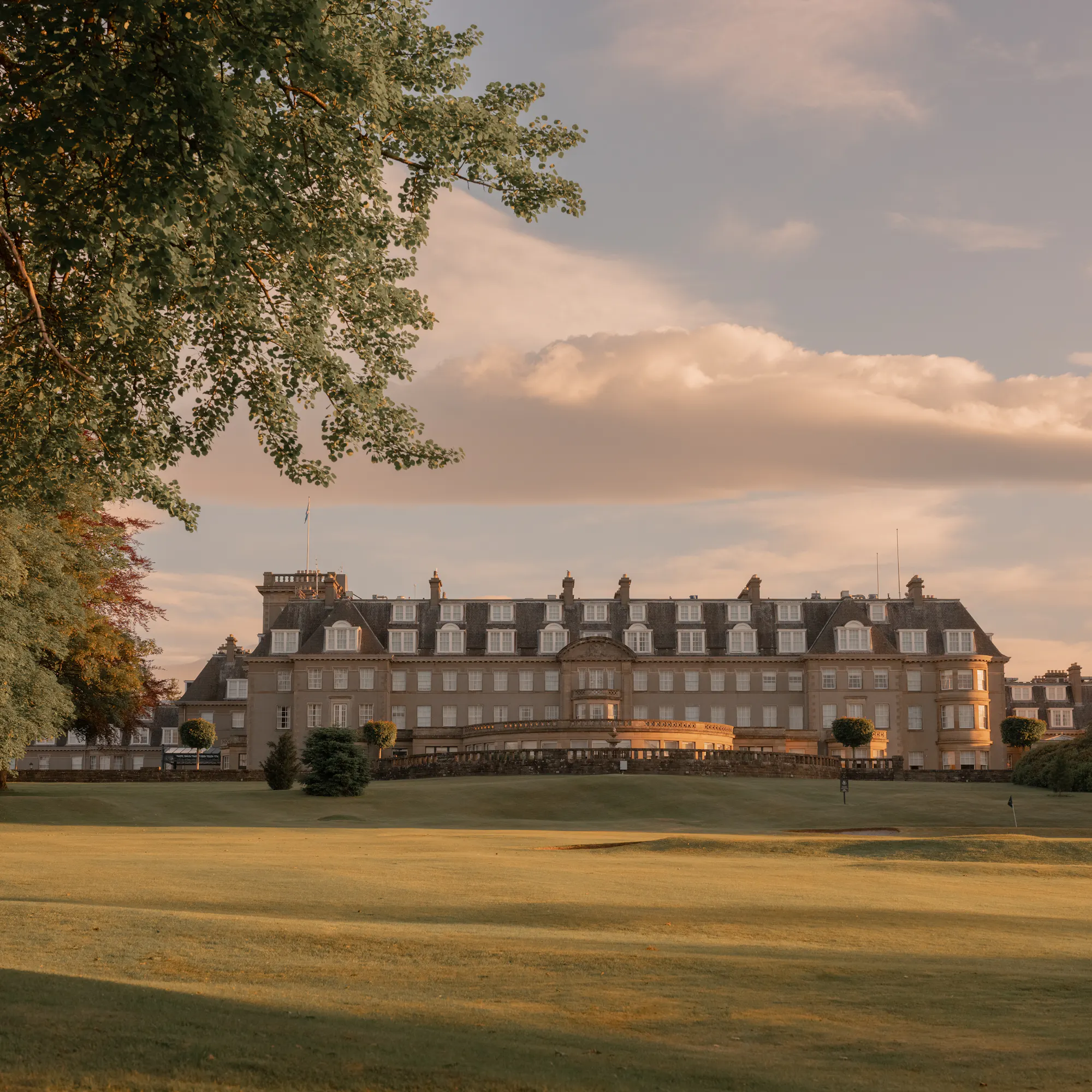 Gleneagles Hotel at sunset, its sandstone facade overlooking the golf course.
